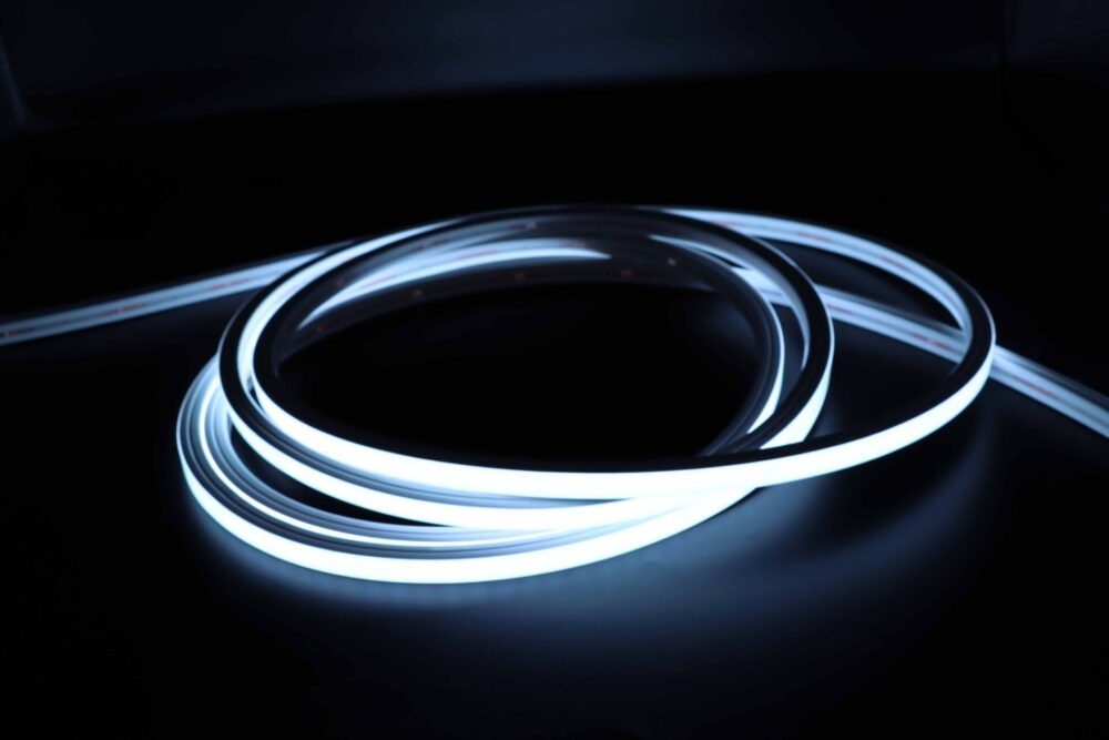 Illuminated white neon flex LED strip coiled in dark environment