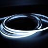 Illuminated white neon flex LED strip coiled in dark environment