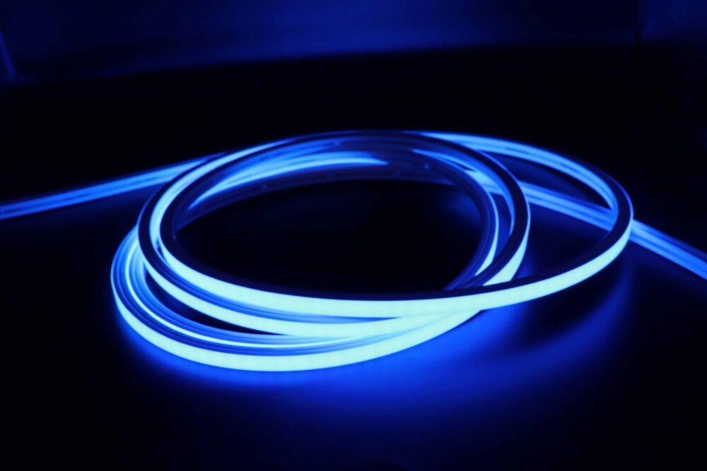 Blue illuminated neon flex LED strip coiled in dark environment