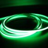 Green illuminated neon flex LED strip coiled in dark environment