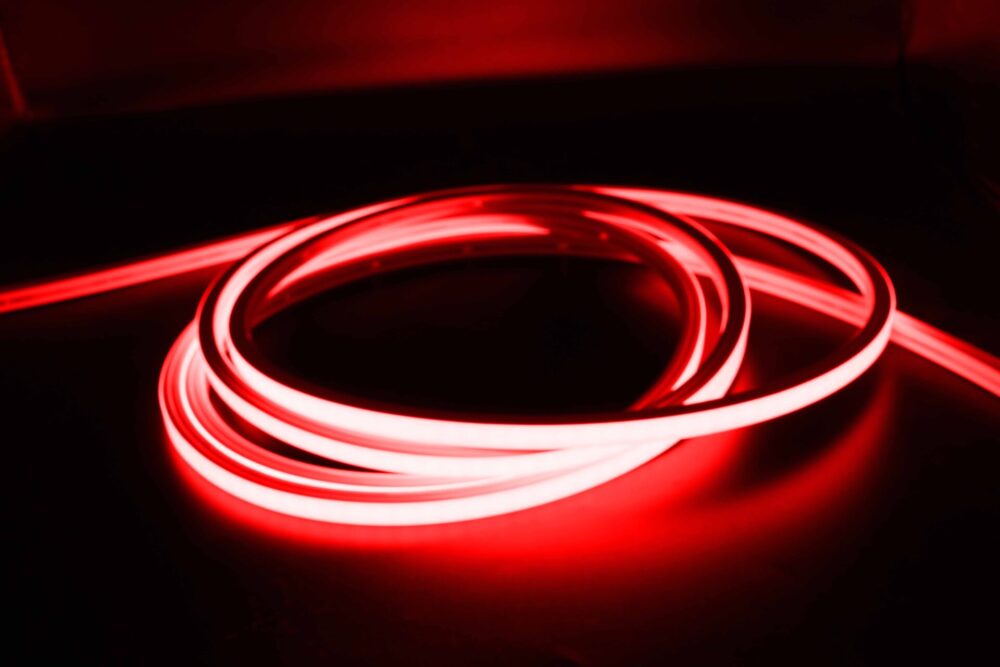 Red illuminated neon flex LED strip coiled in dark environment