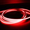 Red illuminated neon flex LED strip coiled in dark environment